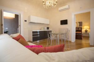a living room with a table and a kitchen at Bed&Breakfast JSuite in Gioia del Colle