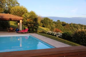 een zwembad in een tuin met een tuinhuisje bij Le Vallon de Saint André in Limonest