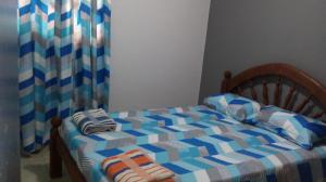 Cama pequeña con manta blanca y azul a cuadros en Casa de las NONAS en Salta
