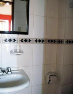 a bathroom with a sink and a mirror at Hostal El Candelabro in Pisco