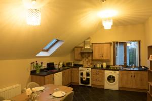 a kitchen with a table and a stove top oven at Quarry Loft in Magherafelt