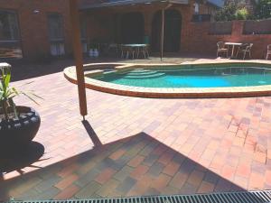 a swimming pool in a yard with a patio at Hotel Cavalier in Wantirna South