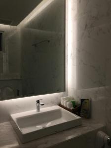 W łazience znajduje się biała umywalka i lustro. w obiekcie NirvaNAN House w mieście Nan