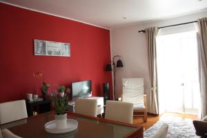 リスボンにあるCastle View Mouraria - 6 personsの赤い壁のリビングルーム(白い椅子付)