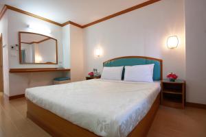 - une chambre avec un grand lit et un miroir dans l'établissement P.A. Place Hotel, à Nakhon Sawan