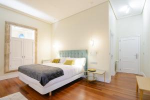 a bedroom with a bed and a table and a window at Pazo de Mendoza in Baiona