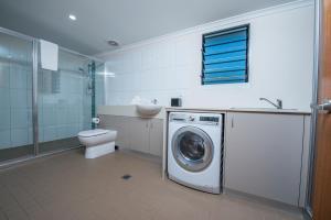 a bathroom with a washing machine and a toilet at Club Tropical Resort Darwin in Darwin