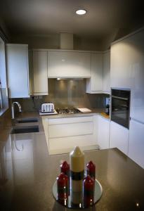 a kitchen with white cabinets and a plate on a table at Zenobia London Luxury Apartments in Finchley