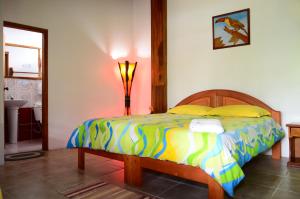 a bedroom with a bed with a colorful comforter at Hostal Las Palmas in Puyo