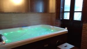 a large tub with green water in a bathroom at La Currada in Taranes +30 photos