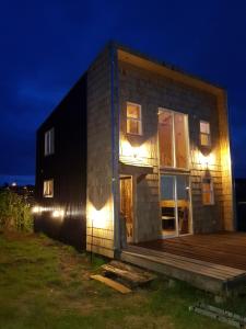 a house with lights on the side of it at night at Cabaña Loft del Sur Premium in Chonchi