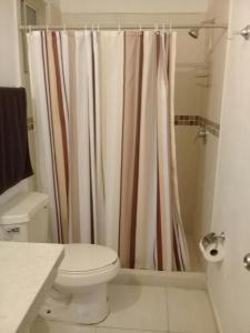 ein Bad mit einem Duschvorhang und einem WC in der Unterkunft Consulado Suites in Monterrey