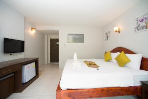 a bedroom with a bed and a television in it at Srichada Hotel Khaolak - SHA Extra Plus in Khao Lak