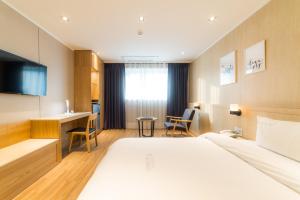 Pokój hotelowy z łóżkiem i biurkiem w obiekcie Reborn Suwon Silkroad Hotel w mieście Suwon
