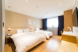 Postel nebo postele na pokoji v ubytování Reborn Suwon Silkroad Hotel