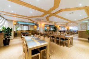 comedor con mesas y sillas de madera en Reborn Suwon Silkroad Hotel en Suwon