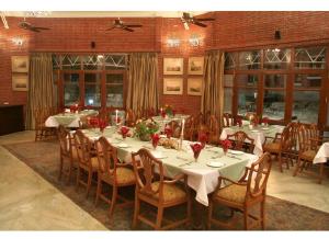 una grande sala da pranzo con tavoli e sedie con fiori di WelcomHeritage Taragarh Palace a Kangra