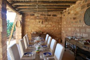 una sala da pranzo con un lungo tavolo e sedie bianche di Dimora Cala del Pozzo a Favignana Altre 34 foto