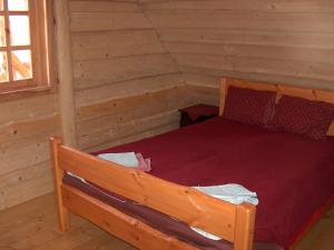 a bedroom with a bed in a log cabin at Zirgu sēta "Klajumi" - Horse ranch "Klajumi" in Kaplava