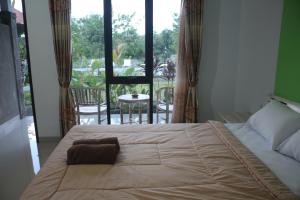 a bedroom with a large bed with a view of a patio at Paranyogan Homestay in Uluwatu