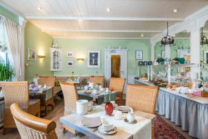 a restaurant with tables and chairs in a room at Hotel Berlin in Wenningstedt