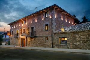 un edificio de ladrillo con luces en el lateral. en Hotel Boutique Real Casona De Las Amas en Azofra