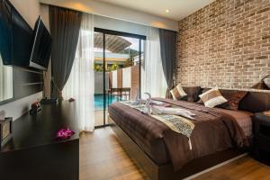 a bedroom with a large bed and a brick wall at KG Private Pool Villa in Ao Nang Beach