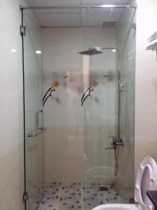 a shower with fish on the wall in a bathroom at Queen Hotel in Quy Nhon