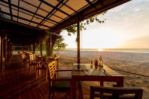 a restaurant with a table and chairs on the beach at Bangsak Village - Adults Only - SHA Extra Plus in Khao Lak