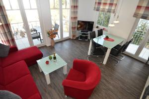 - un salon avec des chaises rouges et une table dans l'établissement Villa Rosa - Apt. 05, à Sellin