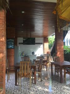 a dining room with wooden tables and chairs at Satria Bungalow in Uluwatu