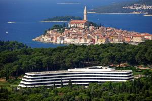 a large building on top of a hill next to the water at Lone Hotel by Maistra Collection in Rovinj