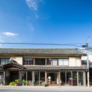 a building with a lot of windows on a street at Guest House Kura in Suzaka