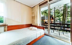 a bedroom with a bed and a large window at Willa Strumyk in Karpacz