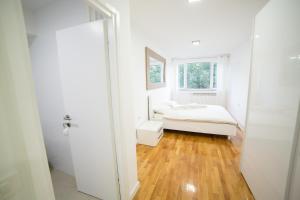 um quarto branco com uma cama e uma janela em Bor Apartment em Bor