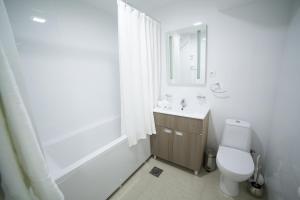 Baño blanco con aseo y lavamanos en Bor Apartment en Bor