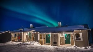 una casa con las luces del norte en el cielo en Camp Ripan, en Kiruna