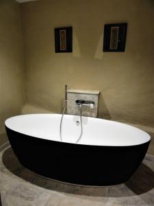 a bath tub in a bathroom with two pictures on the wall at Domaine des Maréquiers chambre Pimprenelle in Saint-Germain-du-Teil +17 photos