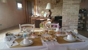 a table with a white table cloth with food on it at Il Rifugio del Poeta in San Biagio di Callalta