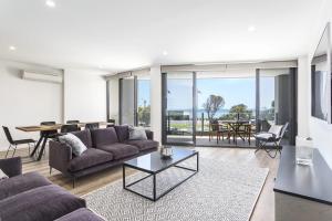 a living room with a couch and a table at Blairgowrie Apartment 1 - on the beach in Blairgowrie