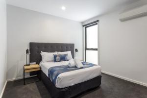 a bedroom with a king sized bed with a window at Blairgowrie Apartment 1 - on the beach in Blairgowrie