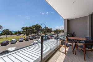 a balcony with a table and a view of a highway at Blairgowrie Apartment 1 - on the beach in Blairgowrie
