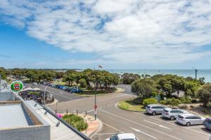 a street with cars parked in a parking lot at Blairgowrie Apartment 2 - on the beach in Blairgowrie