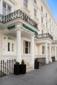 a white building with columns and a balcony at Park Avenue Bayswater Inn Hyde Park in London