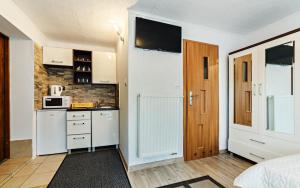 カルパチにあるWilla Strumykの電子レンジ付きのキッチン、ドアが備わる客室です。