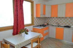 a kitchen with orange and white cabinets and a table at La Casarella Apartment Positano - Stunning View in Positano +8 photos