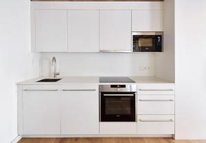 a white kitchen with white cabinets and a sink at Decô Apartments Barcelona-Born Apt. in Barcelona