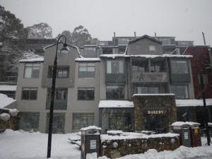 a snow covered building with a street light and parking meters at Thredbo 31 in Thredbo