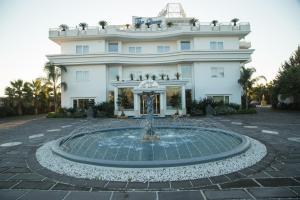 un edificio con una fontana di fronte a un edificio di Hotel The Queen a Pastorano