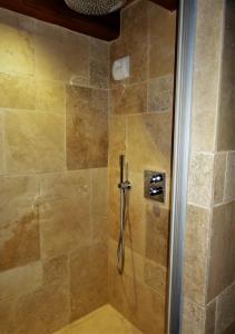 La salle de bains est pourvue d'une douche et d'une porte en verre. dans l'établissement Domaine des Marequiers chambre Alchemille, à Saint-Germain-du-Teil